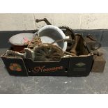 A box containing late 19th and 20th century metal ware including three large weights, cogs,