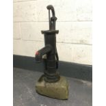 A cast iron water pump mounted on stone base