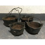 A set of four graduated cast iron cauldrons