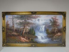 A gilt framed oil on board depicting a waterfall in a wooded landscape