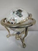 A gemstone globe on three way stand