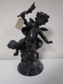 A spelter figure of a cherub on circular marble base