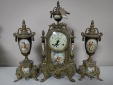 A three piece continental brass clock garniture with porcelain panels