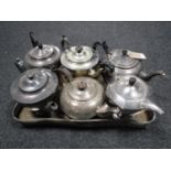 A tray of six antique plated teapots on gallery tray