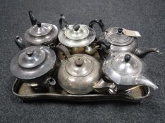 A tray of six antique plated teapots on gallery tray