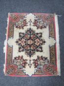 A small fringed floral hearth rug on pink ground