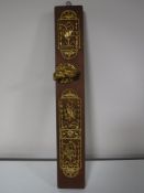 A pine board mounted with brass ornate door furniture