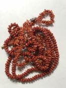 Two coral necklaces together with one other long necklace.