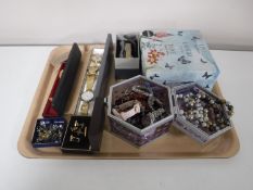 A tray containing a collection of assorted costume jewellery, wristwatches,