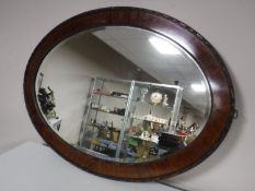 An early twentieth century oval mahogany framed bevelled mirror