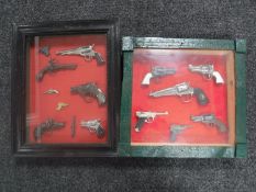 Two display frames containing a collection of miniature replica pistols