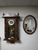 A mahogany cased wall clock together with an oval copper framed bevelled mirror