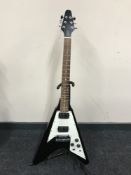 A flying V electric guitar on stand