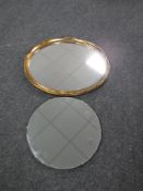 An oval gilt framed mirror together with an early 20th century circular bevelled edge mirror