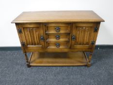 An oak linen fold side cabinet