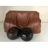 A leather bag containing two sets of lawn bowls