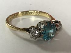 An 18ct gold blue zircon and diamond three stone ring, size L.