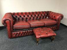 A red button leather three seater Chesterfield settee with stool