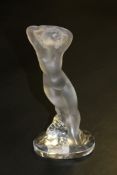 A Lalique crystal figurine : Nude study of a maiden with arms aloft leaning against a rock,