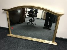 A shaped gilt framed bevelled overmantel mirror