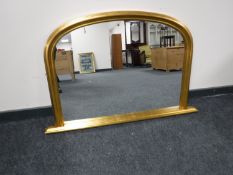 A gilt framed arched overmantel mirror