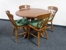 A circular pine pedestal kitchen table and four chairs