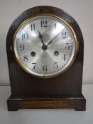 An oak dome top mantel clock with pendulum and key