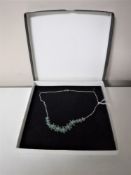 An emerald floral necklace on silver chain