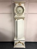 A continental cream and gilt longcase clock with pendulum and weights,