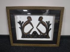 A tribal carving of two figures in a frame