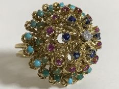 A high carat gold multi-gemstone ring, set with tiers of turquoise, emeralds, rubies,