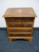 A miniature five drawer chest on bracket feet