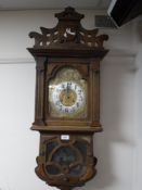 An early 20th century oak cased wall clock with brass dial