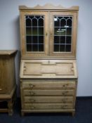 A blonde oak leaded door bureau bookcase