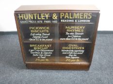 A mahogany sliding door bookcase with "Huntley & Palmers" sign writing