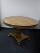 An oval pedestal breakfast table on paw feet