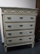 An early 20th century pine cream and gilt painted five drawer chest
