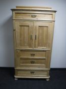 An antique stripped pine hall cupboard