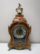 An ornate Franz Hermle mantel clock with pendulum and key