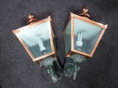 A modern pair of copper wall mounted coach lights