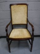 A mahogany armchair in a gold fabric