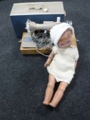 An early 20th century porcelain headed doll and a cased New Home sewing machine