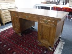 An Edwardian oak twin pedestal desk