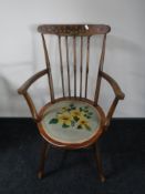 A spindle back armchair with a floral tapestry seat