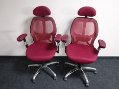 A pair of office ergonomic support armchairs upholstered in a maroon fabric