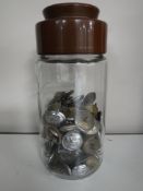 A jar containing a collection of military and service buttons