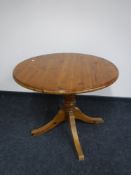 A circular pine pedestal dining table