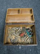 A wooden trinket box containing spent gun shells and a vintage reloading tool