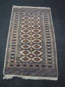 A fringed rug of geometric design on cream ground