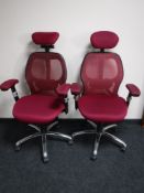 A pair of office ergonomic support armchairs upholstered in a maroon fabric